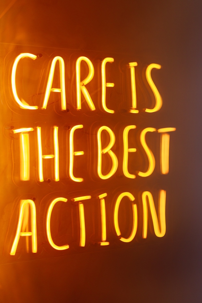 "Care is the best action" written with neon lights